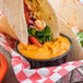 A tortilla with shrimp and vegetables and Hellmann's Ancho Chipotle Sauce in a bowl.