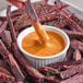A bowl of Hellmann's Real Ancho Chipotle Sauce with a plate of food for dipping.