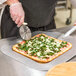 A person using a pizza cutter to slice a Rich's flatbread