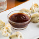 A plate of dumplings with General Tso's sauce.