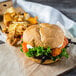 A burger and fries on an Amoroso's Kaiser roll on a wooden board.