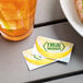 Two True Citrus unsweetened lemon mix packets next to a glass of liquid.