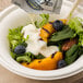 A bowl of salad with Ken's Blue Cheese dressing on a table.