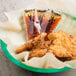 A bowl of fried chicken with Texas Pete hot sauce packets.