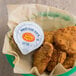 A bowl of Sweet Baby Ray's Buffalo Wing Sauce with fried chicken nuggets.