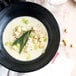A bowl of soup with Fresh Gourmet Plain Cube Croutons and herbs.