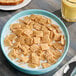 A bowl of Quaker Life Cereal with milk on a white background.