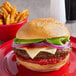 A Country Magic ground beef pizza burger with cheese and vegetables on a plate.