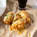 A plate of chicken wings with Sweet Baby Ray's Garlic Parmesan Wing Sauce on a paper tray.