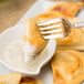 A fork holding a Mrs. T's Classic Cheddar Potato Pierogies
