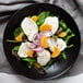 Sliced fresh mozzarella cheese on a salad with orange slices.