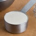 A measuring cup with a white powder in it.