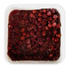 A square plastic container filled with frozen red tart pitted cherries.