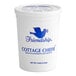 A white Grassland container of small curd cottage cheese with blue text and a blue bird.