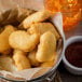 A plate of Pierce tempura battered chicken breast nuggets with a bowl of sauce.