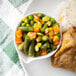 A plate of food with a bowl of mixed vegetables on the side.