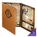 A brown Menu Solutions Bella Collection menu cover on a table with a plate of food.