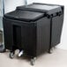 A black plastic Cambro mobile ice bin with wheels.