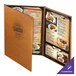 A brown Menu Solutions Bella Collection leather-like menu cover on a table with menus inside.