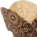 A dark brown paper baking cup with a tan Mariposa print.