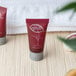 A group of small red Noble Eco Novo Natura shampoo bottles with white text.