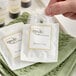 A packaged Novo Essentials hotel and motel shower cap placed on a green washcloth.