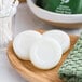 A wooden tray holding a plate of wrapped Noble Eco Novo Terra glycerin soap bars.