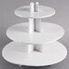 A white three tiered Enjay cupcake stand with a paper cut out shape.