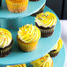 An Enjay blue cupcake stand with cupcakes on it.