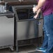 A man standing next to a Manitowoc undercounter ice machine on a counter.