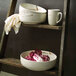 A ladder with bowls and a Oneida Marble porcelain mug on it.