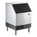 A large silver Manitowoc undercounter ice machine with a black front.