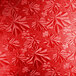 A white background with a red pattern of leaves on a Enjay red round cake drum.