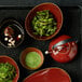 A tray with bowls of food and a Oneida Rustic Crimson teapot with a metal handle.