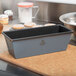 A Matfer Bourgeat flared bread loaf pan on a counter with bread loaves.