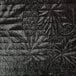 A close up of a black surface with a white quilted pattern.