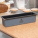 A close-up of a Matfer Bourgeat mini loaf pan filled with bread batter.