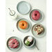 A white plate with a Oneida Studio Pottery Stratus ramekin filled with dessert.