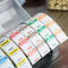 A roll of National Checking Company labels with days of the week on a dispenser.