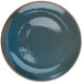 A white porcelain round coupe plate with blue and brown speckles.