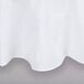 A close-up of a white Intedge round tablecloth with a hemmed edge.