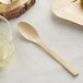 A Bamboo by EcoChoice compostable wooden spoon on a table.