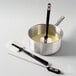 A pot of liquid with a Matfer Bourgeat Elveo spatula with a thermometer in it.