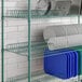 A Regency green wire drying rack shelf holding metal plates.