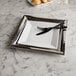 An American Metalcraft square stainless steel tray with a plate, fork, and knife on it.