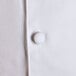 A close up of a white Chef Revival chef coat with a black button.
