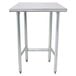 An Advance Tabco stainless steel work table with an open base and metal legs.