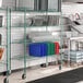 A metal rack with green epoxy shelves holding dishes.