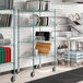 A kitchen with a green metal wire rack holding trays.