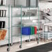 A green Regency wire rack with trays on it.